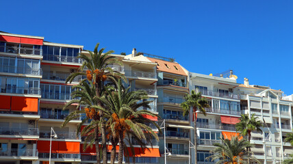Obraz premium Street resort town in Spain, beautiful houses, bright balconies, a palm tree with orange fruits. Beautiful landscape, travel advertisement, Altea, Alicante