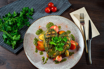Grilled heart-shaped chicken breast with fresh tomatoes and chimichurri sauce.