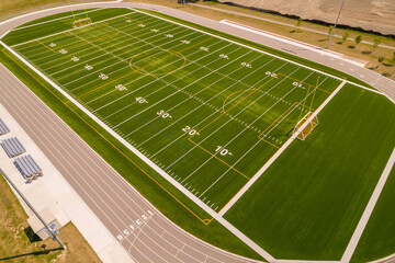 Soccer field grass view. Football field with green grass and white paint lines and marks. Sports soccer and football with nice green environment. Recreational activity ground. © desertsands