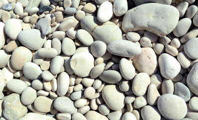 Texture of white sea stones close-up, round smooth stones. For design, background, postcards, collages and compositions