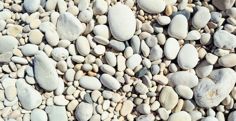 Texture of white sea stones close-up, round smooth stones. For design, background, postcards, collages and compositions