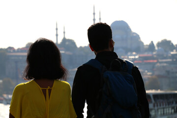 A couple watching the magnificent view of the Bosphorus with mosque silhouettes in the background