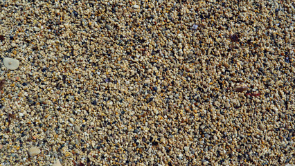Texture of coarse sea sand close-up, small pebbles. For design, background, postcards, collages and compositions