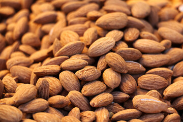 fresh peeled raw almonds ready for sale on counter, background