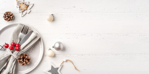Christmas place setting on white wooden table. Copy space for text.