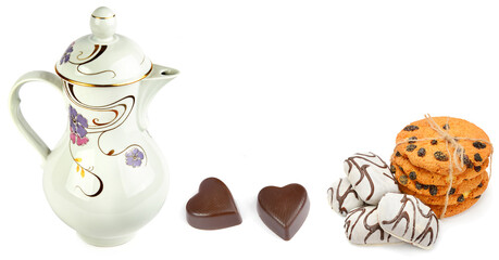 porcelain teapot , Heart shaped chocolates and cookies isolated on white background. Free space for text. Wide format.