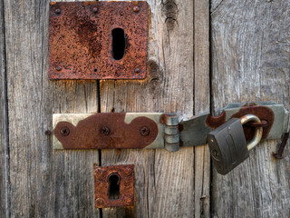 serrure et cadenas rouillés sur une vieille porte en bois
