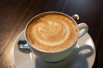 Coffee with foam on the table in the dark