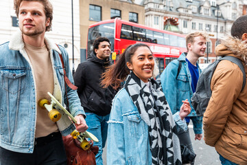 Multiracial group of friends walking and having fun together in London