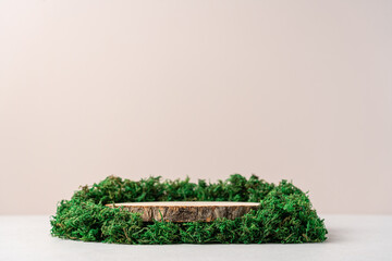 Wooden podium surrounded by moss on a beige background. Concept scene stage showcase, product,...