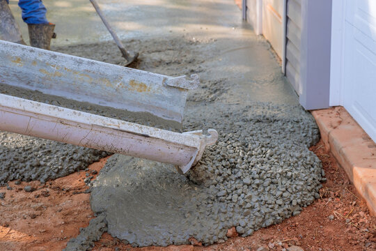 While paving driveway, construction contractors are while pouring wet concrete