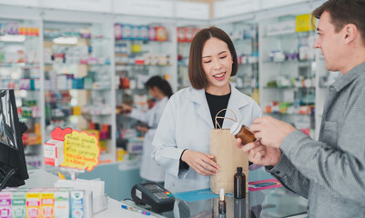 Obraz premium The doctor prescribes the pills according to the customer prescription.Female pharmacist with medical expertise.Business, pharmacy, professional health care.An adult doctor smiling at a drugstore.