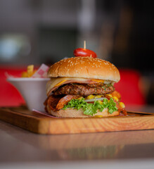 Beef burger with chicken, ham, cheese, sausage, vegetables and French fries