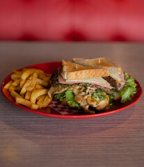 Chicken sandwich with French fries served on a plate