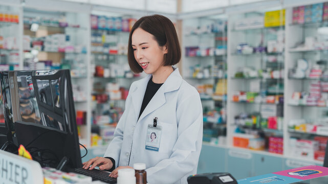 female chemist The pharmacy works at the computer counter.Female pharmacist working at a pharmacy.Business, pharmacy, professional health care.