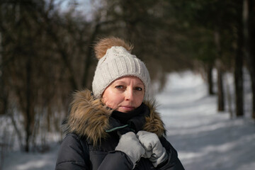 Fototapeta na wymiar Girl in winter clothes on the background of the forest in winter.