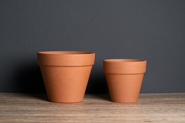 Various size empty terracotta pots with isolated concrete background
