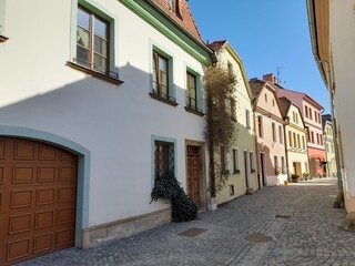 Obraz premium Narrow street in old city. Czech republic. Romantic street with flowers.