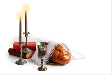 Challah bread covered with a special napkin, shabbat wine and candles on white bacground. Traditional Jewish Shabbat ritual. Shabbat Shalom.