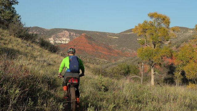 male cyclist is riding a fat mountain bike on a single track trail in Red Mountain Open Space in Colorado, fall scenery