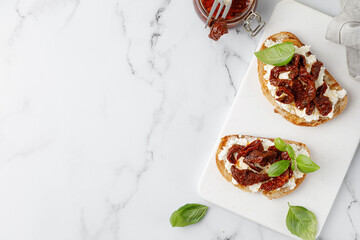 Bruschetta, snack, appetizers. Toast with cottage cheese, ricotta cheese, dried tomatoes in oil and...