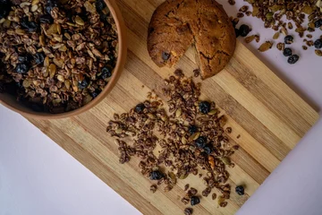  Top view of a bowl of homemade nut and choco granola with a chocolate cookie on a wooden board © Oksana Taran/Wirestock Creators