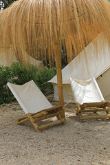 tienda de campaña de loneta blanca con sillones  y sombrilla de paja camping de lujo 4M0A1299-as22