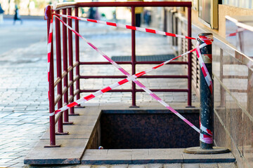 The entrance to the basement is closed with striped tape - obrazy, fototapety, plakaty