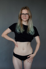 Fototapeta premium Portrait of young amazing good-looking woman showing stretch marks on naked belly, hips, putting hand on waist. Health.