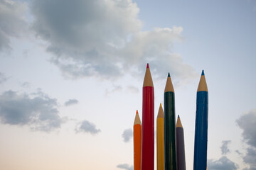 Colorful pencils, crayons at sky background. Palette. Education, school, student, and writing concept.