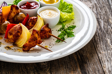 Chicken skewers - grilled meat with vegetables on wooden background
