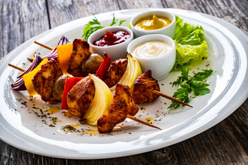 Chicken skewers - grilled meat with vegetables on wooden background
