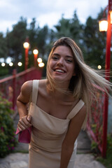 Happy beautiful girl smiling. She is in front of red bridge. 