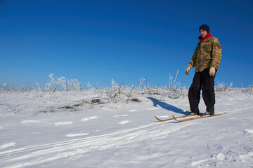 Fototapeta na wymiar military in winter,Ukrainian military man descends from the mountain on skis