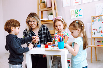 Teacher with children have fun and playing games, learning alphabet and numbers by arts in kid...