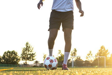 Football player on the field running with the ball. Close up of player's feet running with the ball on the field. Player feet with the ball scoring a goal © Ivi - Powerlightss