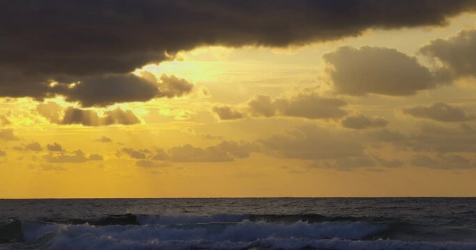 Tropical sea sunrise with scenic cloudscape over ocean waves