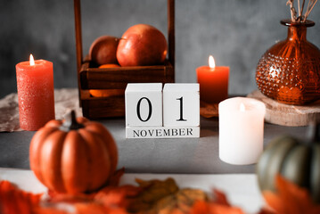 wooden calendar 1 st november. autumn decor apples candles and pumpkins