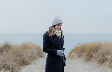 Woman on Baltic Sea beach in winter with contemplative mood