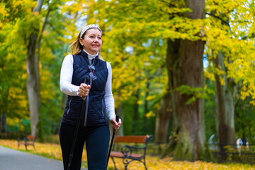 Nordic walking - woman training in city park
