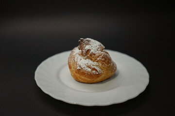 Eclair on a plate black background 