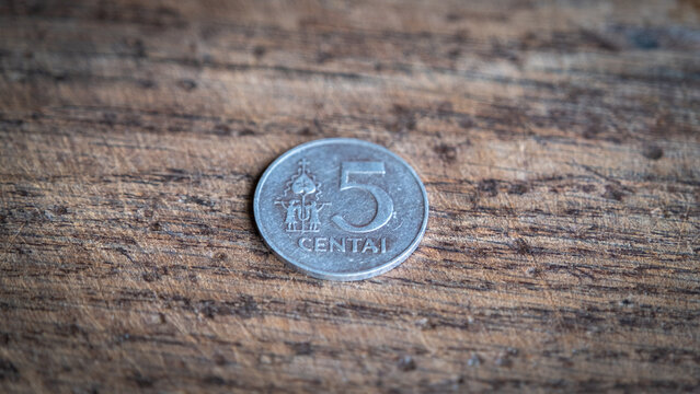Five Lithuanian cents coin isolated on wooden background.