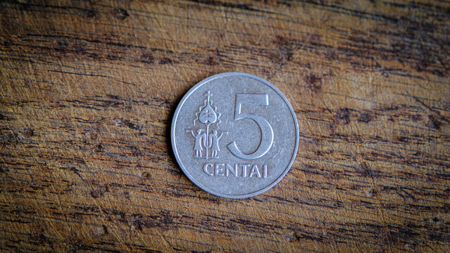 Five Lithuanian cents coin isolated on wooden background.