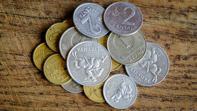 Various old Lithuanian coins isolated on wooden background.