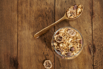 granola with dried fruits in a jar on a wooden table