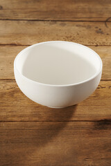 empty white bowl on a wooden table