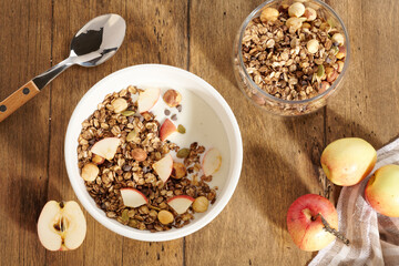 granola with yogurt and berries in a white bowl on a wooden table