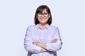 Portrait of confident middle-aged business woman on light background