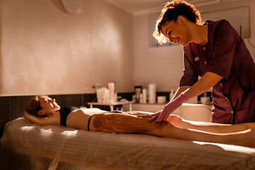 Happy young woman during a chocolate wrap or massage in spa salon