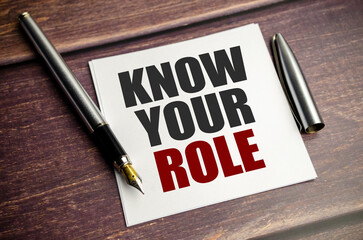 know your role words on notebook and wooden background